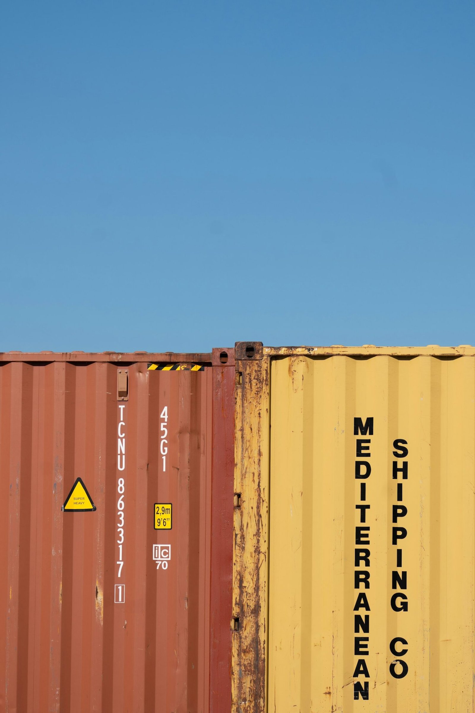 Shipping containers against a bright blue sky